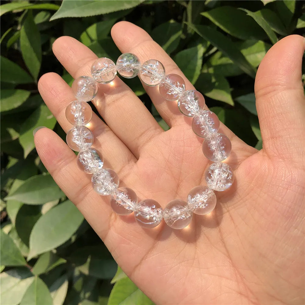 Clear Quartz round-bead bracelet held in an open hand, alternate variant view.