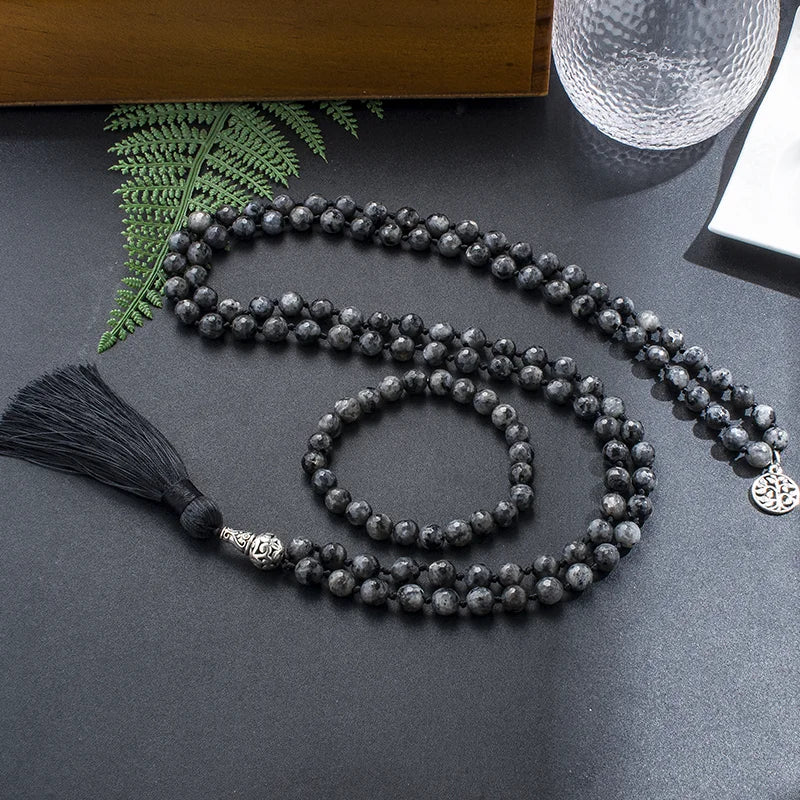 Labradorite mala and matching bracelet arranged together on a dark styled surface.