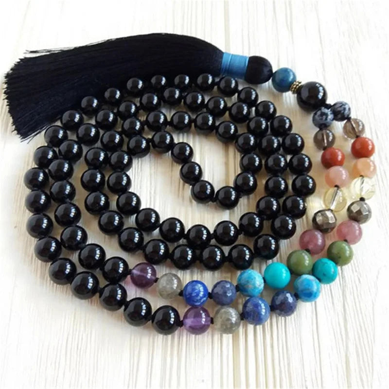 Close view of coiled Black Tourmaline mala beads, multicolor accents, and black tassel.