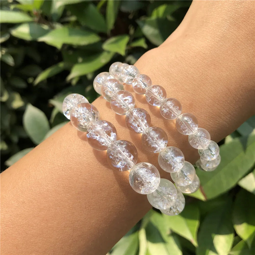 Clear Quartz bead bracelets worn on a wrist in sunlight, alternate view.