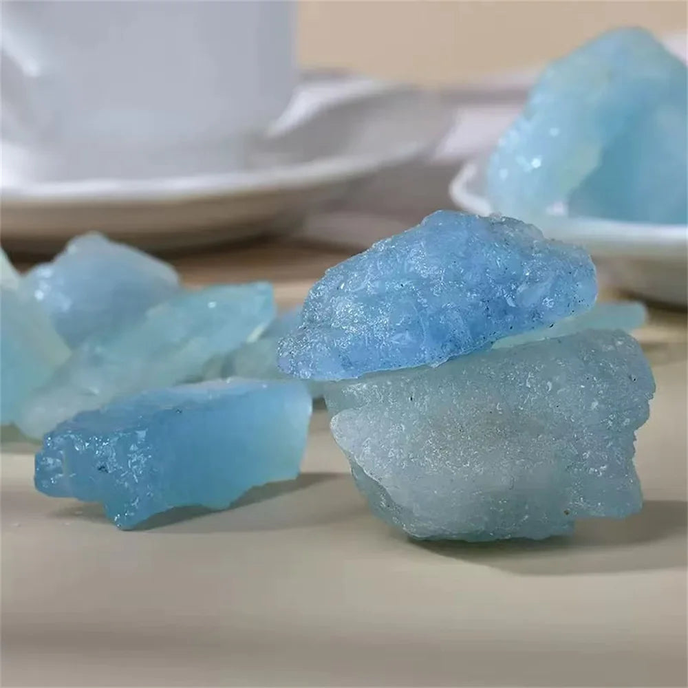 Close-up group of rough Aquamarine pieces showing varied blue tones and natural surfaces.