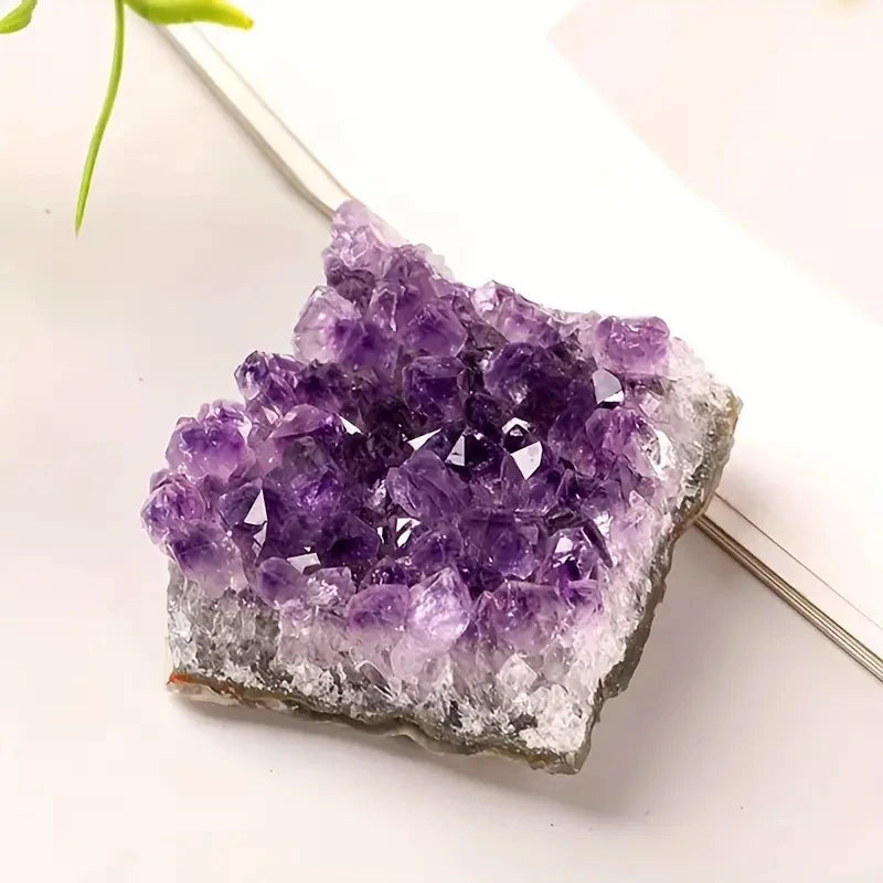Purple Amethyst crystal cluster resting beside an open book in a bright styled setting.