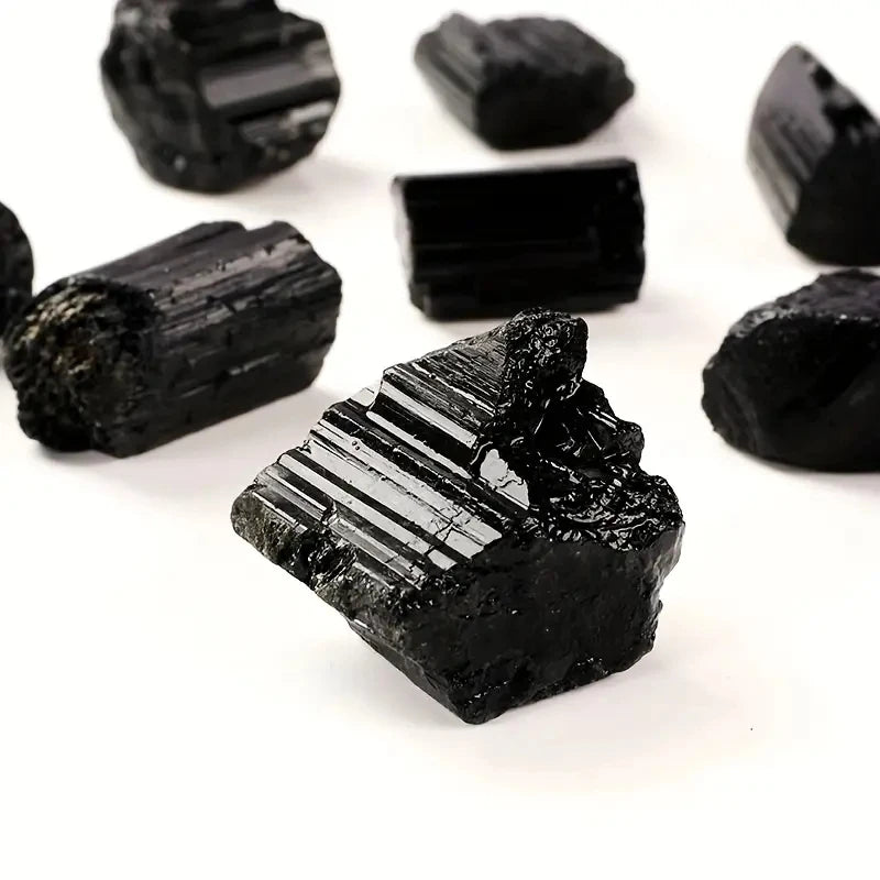 Rough Black Tourmaline crystals isolated on a white background.