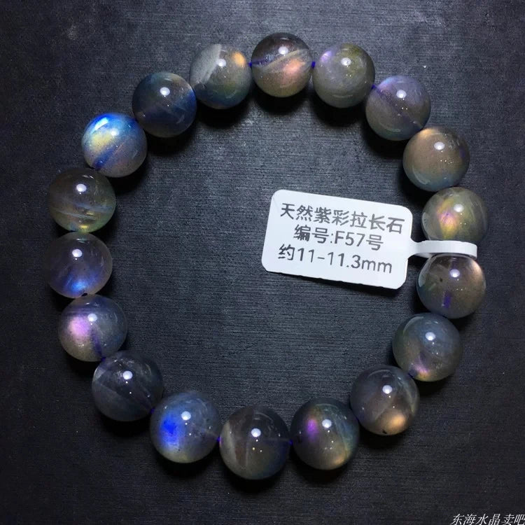 Labradorite bead bracelet on black with a small product label beside the beads.