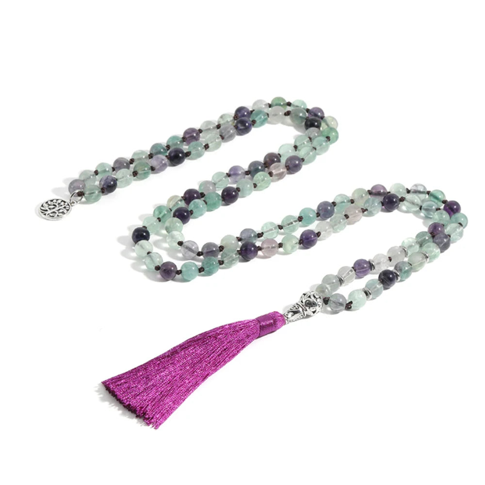 Full green and purple Fluorite tassel mala arranged on a white background.