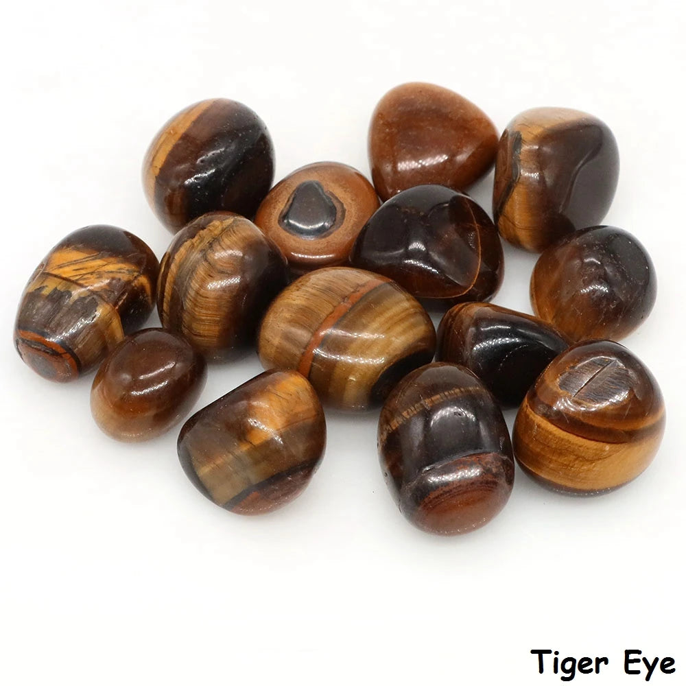Assorted polished Tiger’s Eye tumbled stones showing golden-brown banding on a white background.