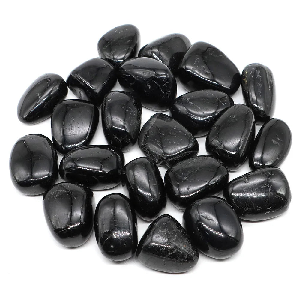 Pile of polished black Black Tourmaline tumbled stones showing varied natural shapes.