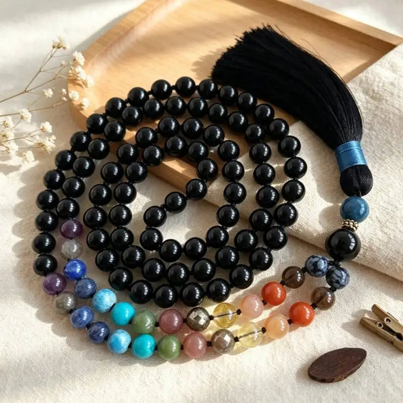 Black Tourmaline tassel mala styled on a warm tray with multicolor accent beads.