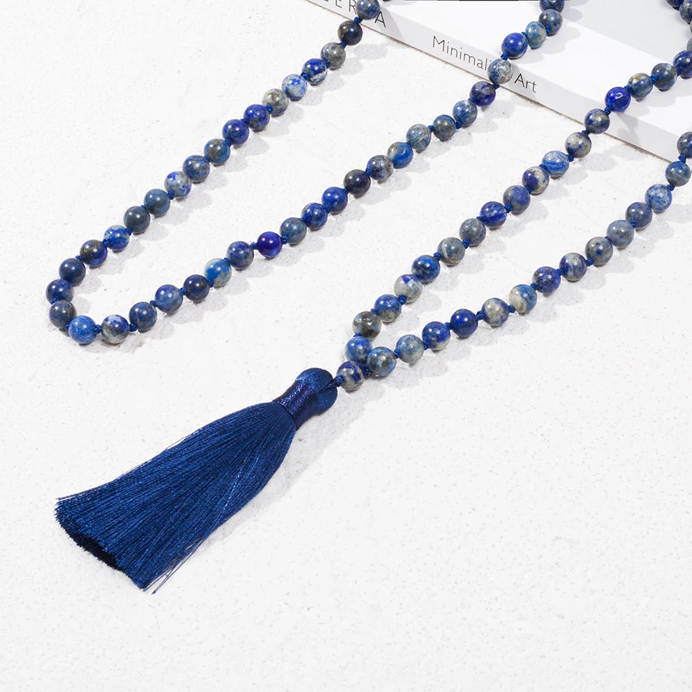 Lapis Lazuli mala laid in long loops on a white surface, alternate view.