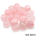 Assorted smooth pale pink Rose Quartz tumbled stones grouped on a white background.