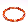 Carnelian round-bead bracelet isolated on white, alternate angle.