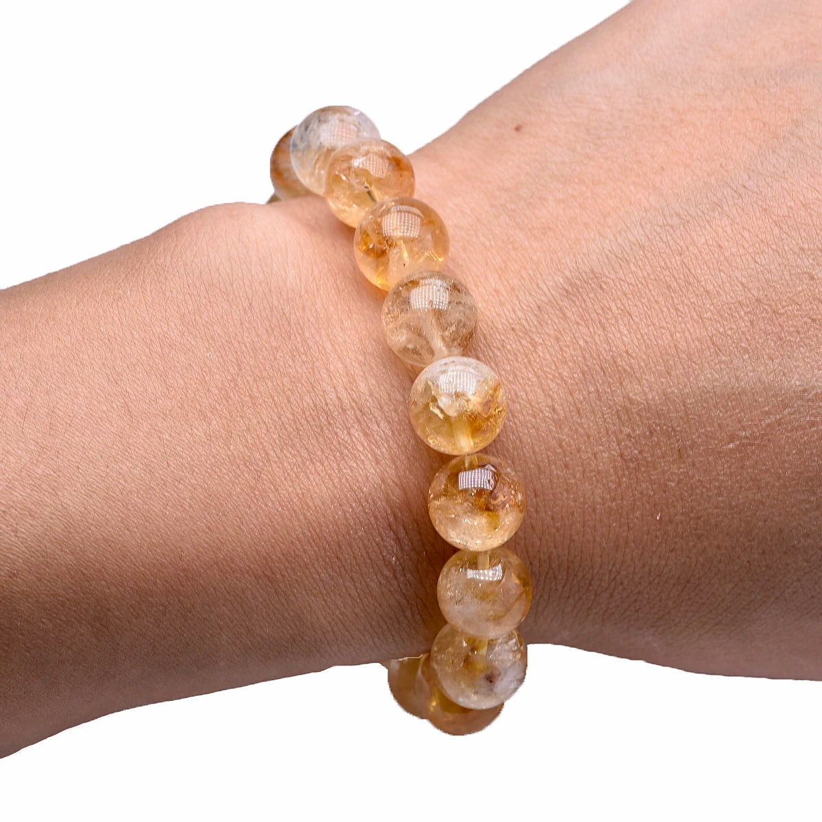 Citrine bead bracelet worn on a wrist against a white background.
