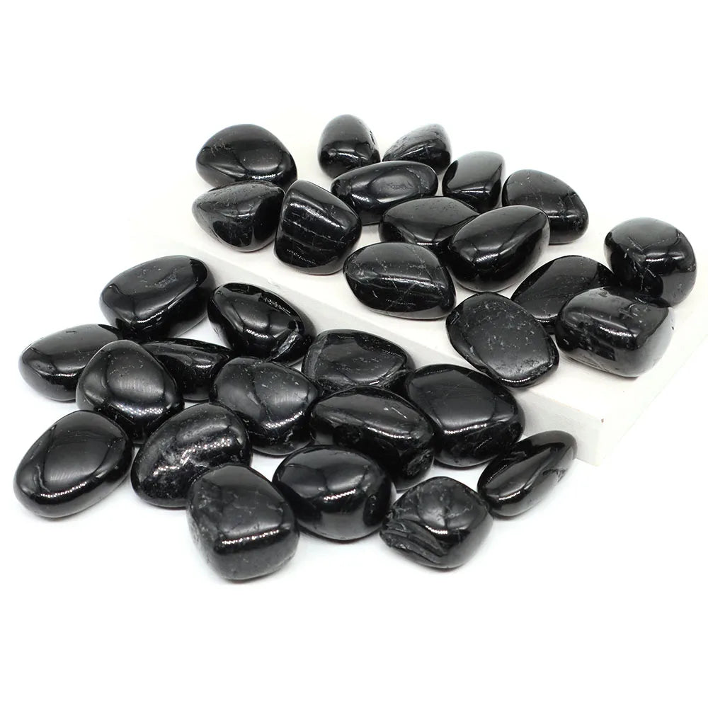 Group of polished Black Tourmaline tumbled stones arranged on white.