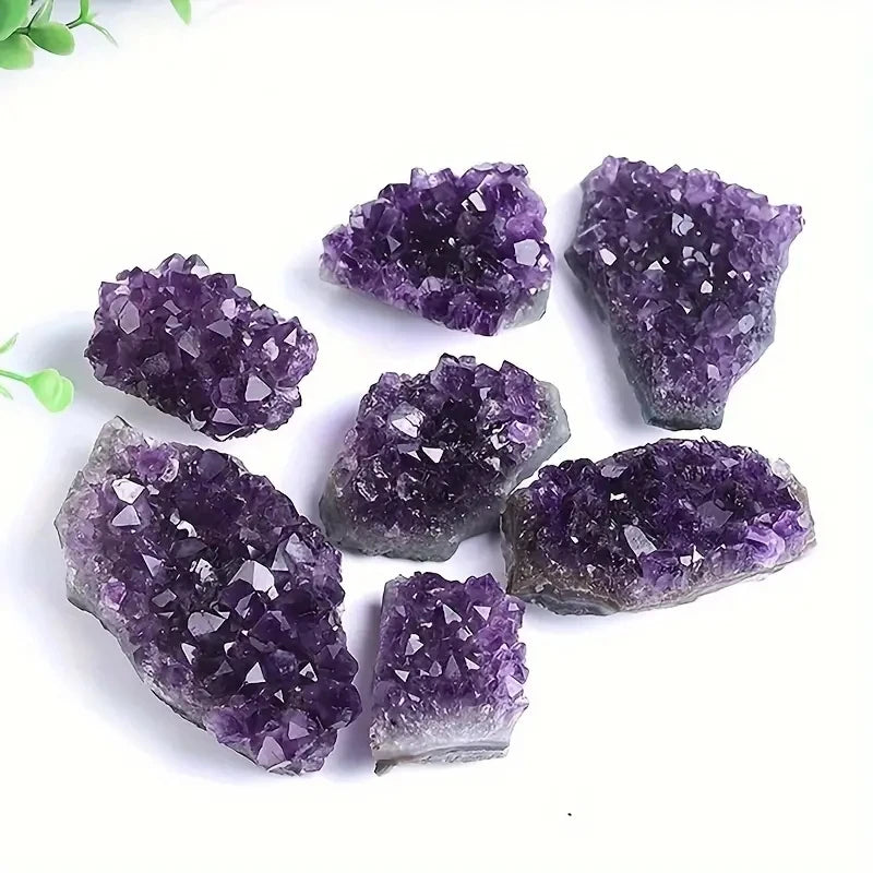 Assorted purple Amethyst clusters grouped on a white background.