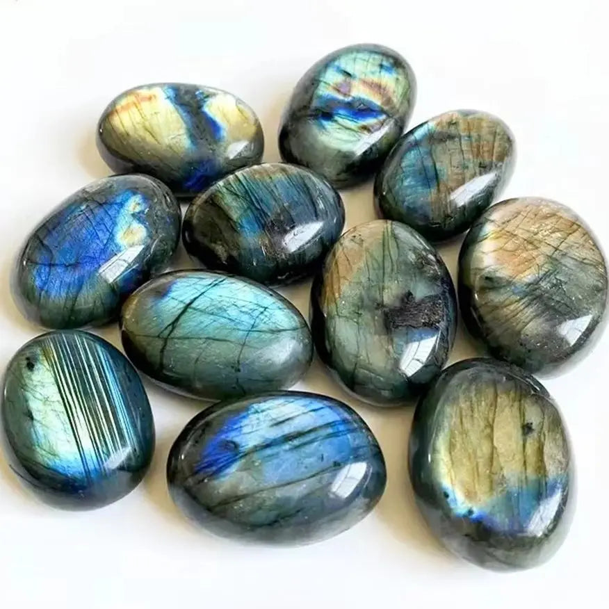 Assorted polished Labradorite tumbled stones on white showing blue and gold iridescence.