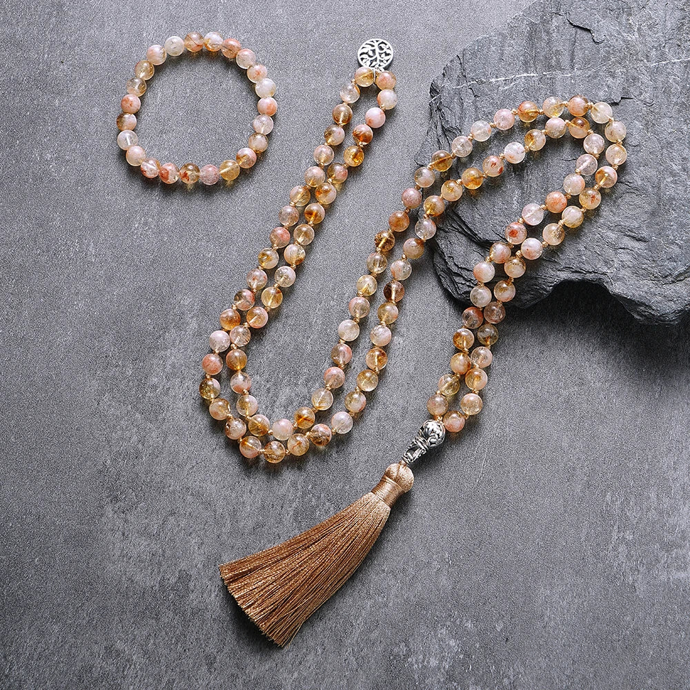 Citrine tassel mala and matching bracelet arranged on a dark textured surface.