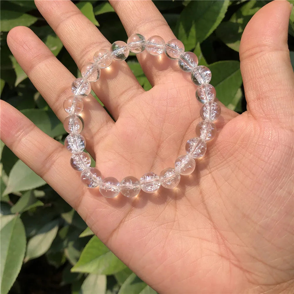 Clear Quartz round-bead bracelet held in an open hand, close alternate view.