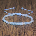 Pale blue Aquamarine rectangular-bead adjustable bracelet displayed on a wood surface.