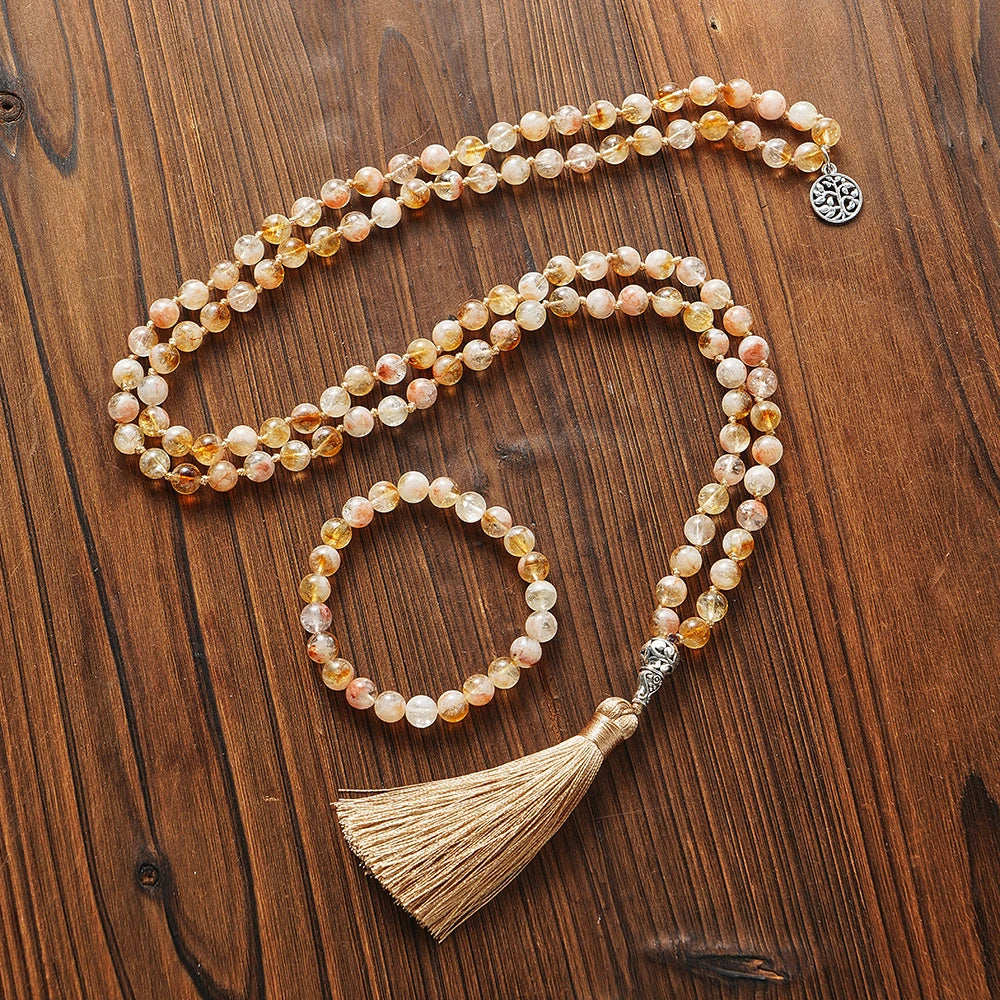 Citrine tassel mala and matching bracelet arranged on a warm wood surface.
