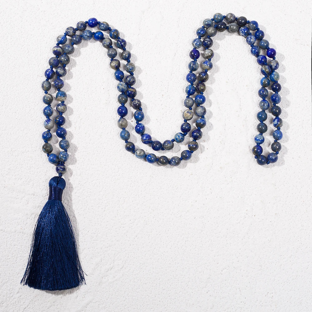 Full Lapis Lazuli mala with dark blue tassel arranged on white.