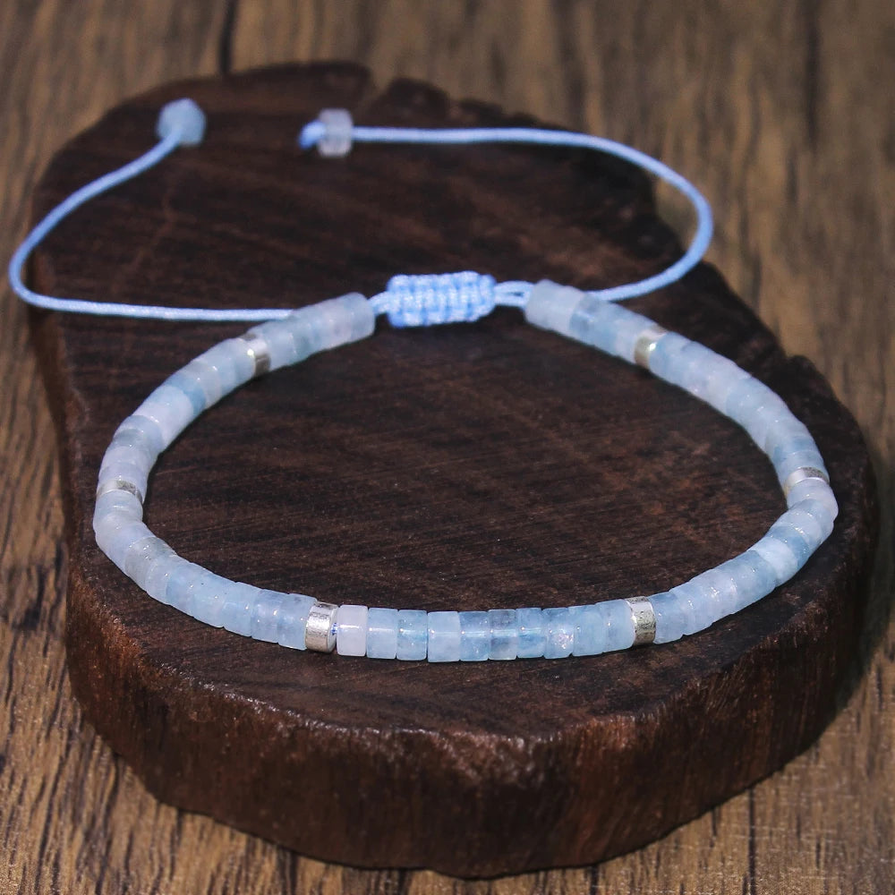 Aquamarine adjustable bracelet shown at an angle on a round wood display.