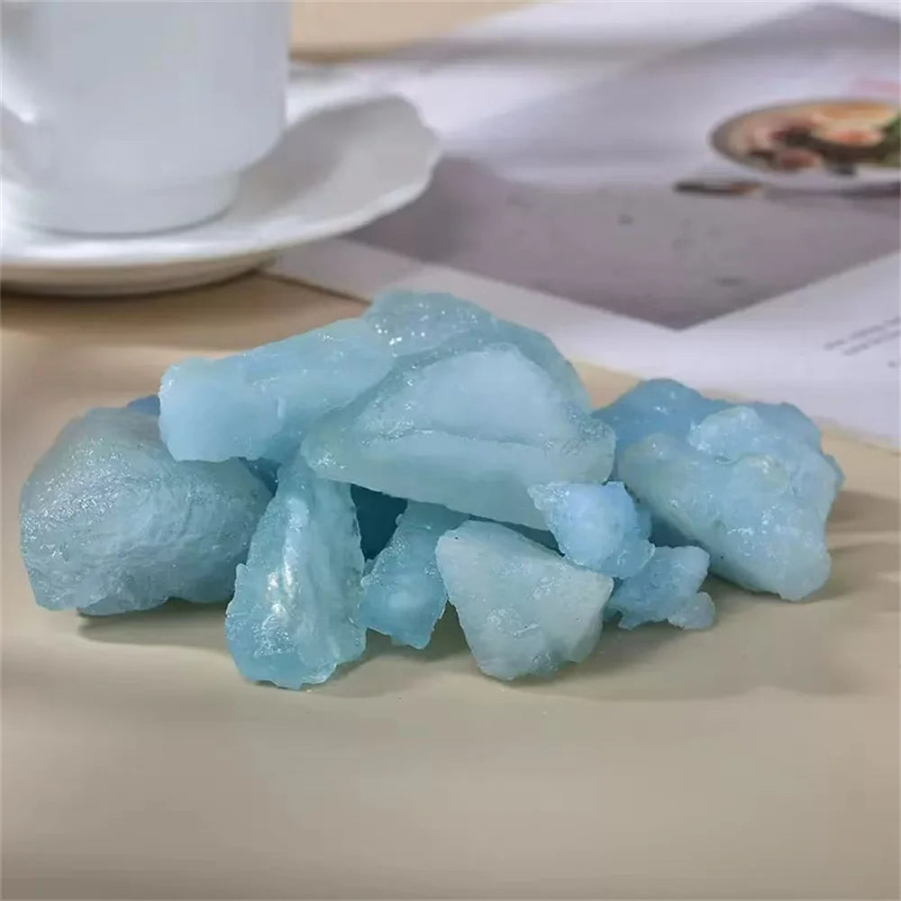 Pile of rough pale blue Aquamarine stones in a styled tabletop setting.