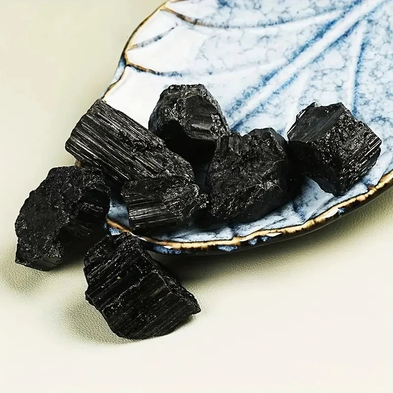 Assorted striated Black Tourmaline crystals arranged on a small decorative plate.