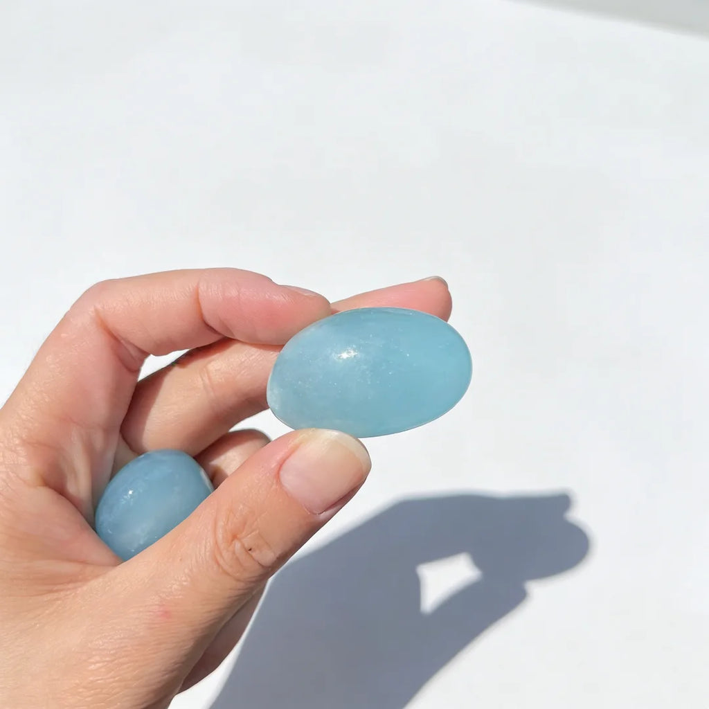 Blue tumbled Aquamarine gemstone with natural mineral patterns