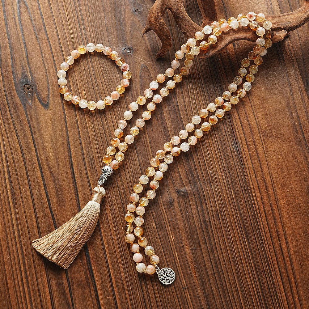 Citrine mala and matching bracelet styled together on a warm wood background.
