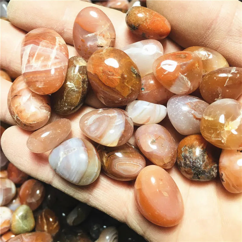 Close view of polished Carnelian stones resting in a hand.