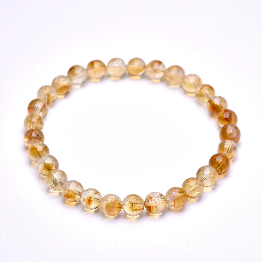 Citrine bracelet with smaller round beads displayed on white.