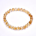 Citrine bracelet with smaller round beads displayed on white.