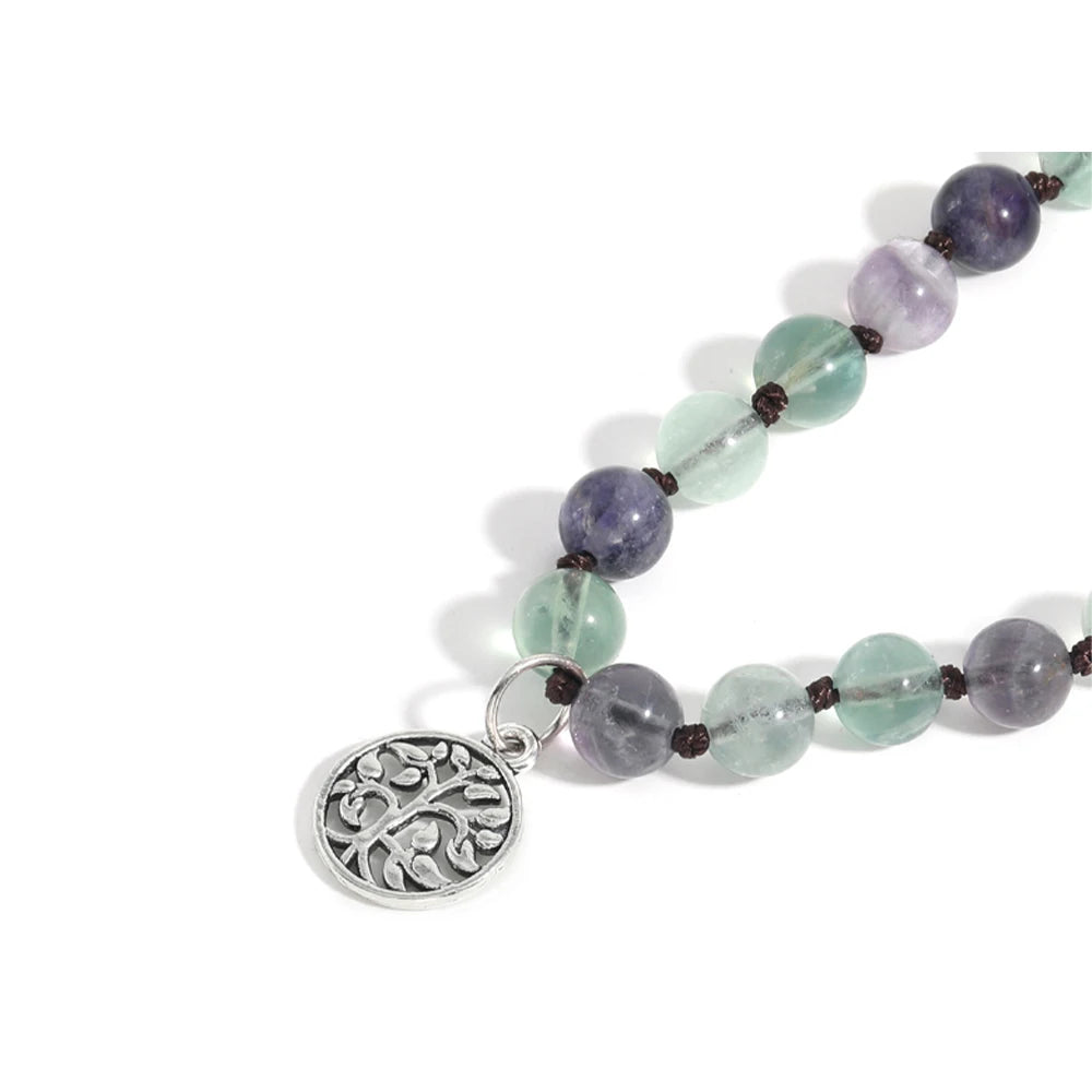 Close-up of green and purple Fluorite beads with a silver tree charm.