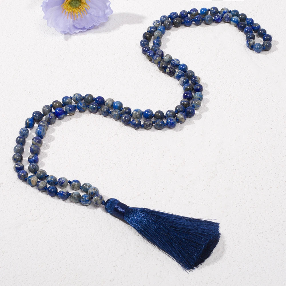 Long Lapis Lazuli tassel mala arranged in a flowing loop on a white background.