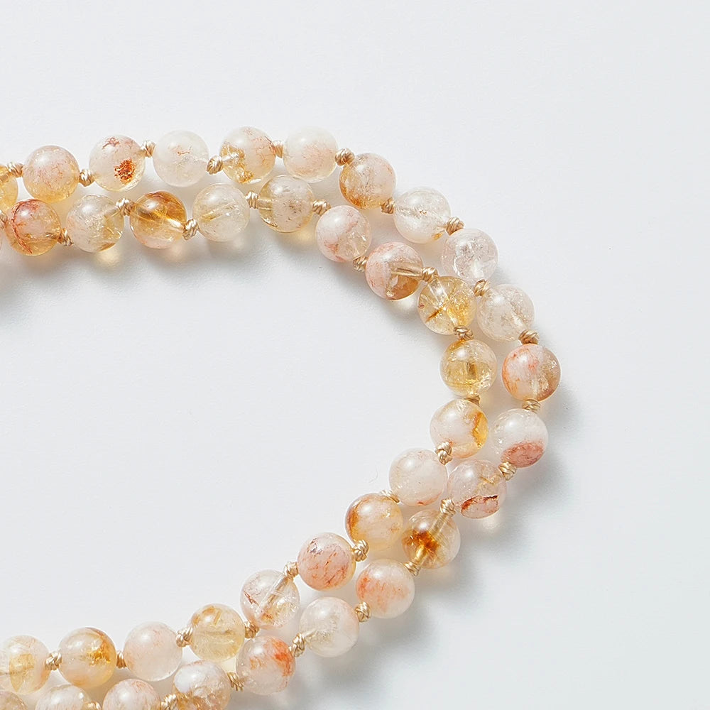 Close-up of pale golden Citrine mala beads and natural inclusions.