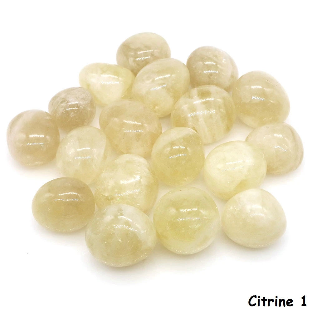 Assorted pale yellow polished Citrine tumbled stones grouped on a white background.
